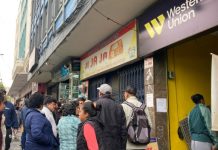 Clientes de Western Union duermen fuera de una sucursal para enviar dinero al exterior